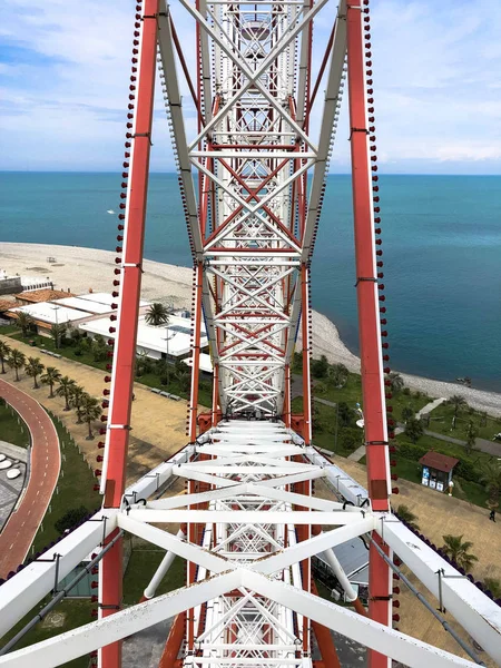 Metallic white iron construction of the pipes, the mechanism of the Ferris wheel is not the backdrop of a seaside resort with palm trees. Inside view