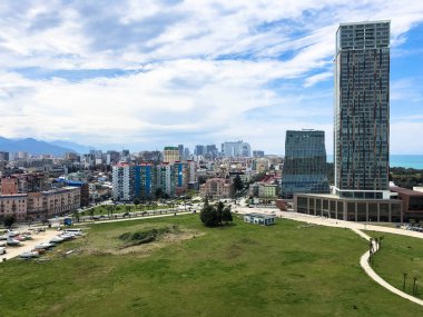 Modern bir büyük şehirde Yeşil park, yüksek cam evler, binalar, tropikal sıcak yazlık, dinlenme dağların mavi gökyüzüne karşı gökdelenler ile megalopolis