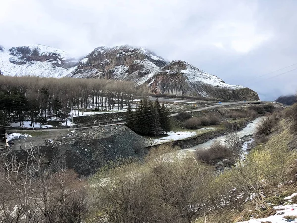 高い山のピークの霧と雪で覆われた美しい山の寒い冬のリゾート風景は、スノーボードや青空に対してスキーのための岩を覆いました — ストック写真