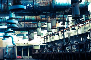 Giriş ve egzoz havalandırması için mavi metal demir büyük borular ile endüstriyel kimyasal petrokimya makine inşa petrol rafinerisi bir atölyede eski paslı soyma tavan