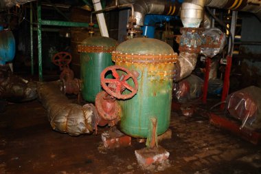 Eski paslı metal demir korozyon ekipmanları ısı eşanjörleri borular kötü terk edilmiş bir endüstriyel rafineri kimyasal petrokimya tesisi atölyesinde pompalar