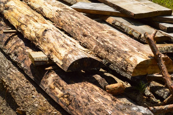 Hole, prkna, dřevěné klády dřevěné, se sudy a pilinami na pilné průmyslové řezání stromů. Pozadí, textura — Stock fotografie