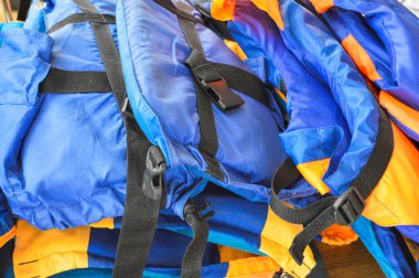 Kauçuk mavi parlak çok renkli hava dolu ve köpük kauçuk can yelekleri boğulma insanların korunması için masada yatıyor