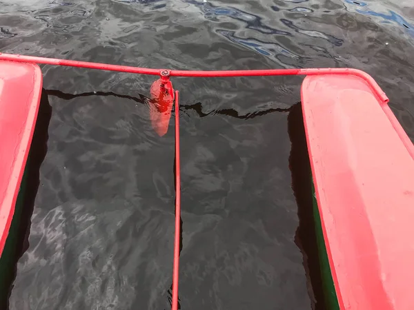 Ferro volante de metal em um catamarã barco vermelho na água — Fotografia de Stock