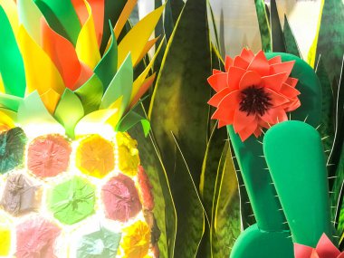 Soyut plastik yapay yeşil parlak parlayan neşeli güzel neşeli Meksika kaktüsleri çiçekleri ile. Arka plan