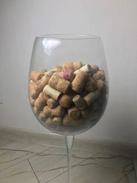 Large decorative glass tumbler, wine glass on a long stem, beautiful filled with wine corks