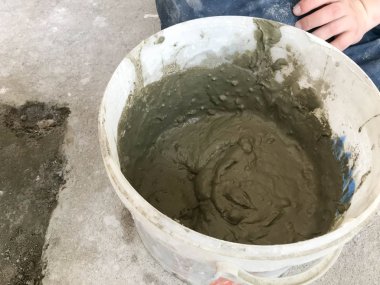 Spatula ve alçı ile büyük beyaz plastik inşaat kova, kiremitli tutkal, bir daire, ev onarımı için çimento, duvarlar tesviye ve yere şap dökme