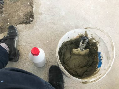 Spatula ve alçı ile büyük beyaz plastik inşaat kova, kiremitli tutkal, bir daire, ev onarımı için çimento, duvarlar tesviye ve yere şap dökme