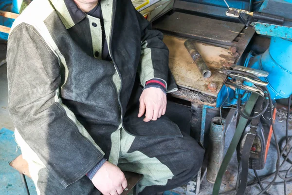 Um trabalhador do sexo masculino, um soldador em roupas de trabalho profissional, trabalha em um — Fotografia de Stock