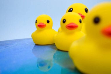 Çocuklarla yüzmek için parlak sarı bir oyuncak ördek okyanusta yüzüyor. Ördekli ördek su yüzeyinde yüzüyor. soyut arkaplan