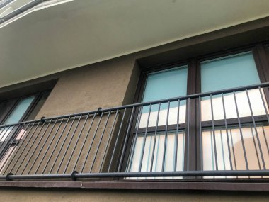 Bir apartmanın teraslarında demir ızgara var. Şehir merkezindeki yeni bir yerleşim yerine, balkon yerine, teraslar eğlence için kurulur. sonbahar koruması