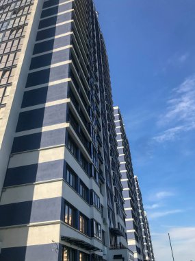 Şehrin merkezinde mavi ve beyaz sütunlu bir ev. Güzel yeni bir alan, şık ve alışılmadık. Orada yaşayanlar için birçok pencere var. Güneşli bir gökyüzünün arka planında