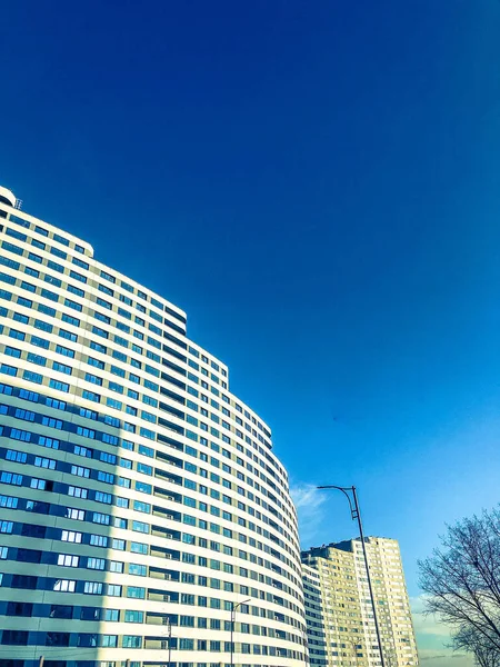 Casa larga blanca en forma de una ola contra un cielo azul brillante. nueva construcción de bloques de colores claros, con ventanas de vidrio en un nivel. inusual diseño de moda de la nueva área. casa — Foto de Stock