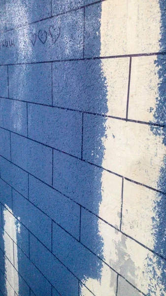 Изготовление декоративной штукатурки, кирпича на стене балкона. будущие кирпичи окрашены черным маркером на синей краске. независимое производство красивой стены — стоковое фото