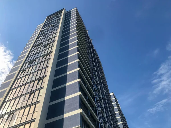 Blaues Glassäulenhaus im Zentrum der Stadt in blau-weiß. mit Fenstern für die Bewohner. schöne stilvolle neue Gegend, in einem ungewöhnlichen Stil eingerichtet. Stadtlandschaft, Urbanismus — Stockfoto