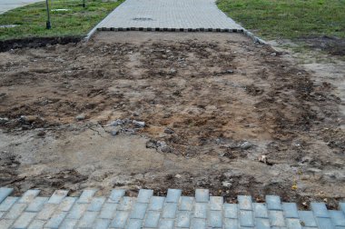 Şehirde bir asfalt yol yok edildi. Parçalanmış asfalt. Beton tuğlalar yeniden yerleştirilmeli. Zemin örtünün altından görülebiliyor. Yollara yeni asfalt seriyor.