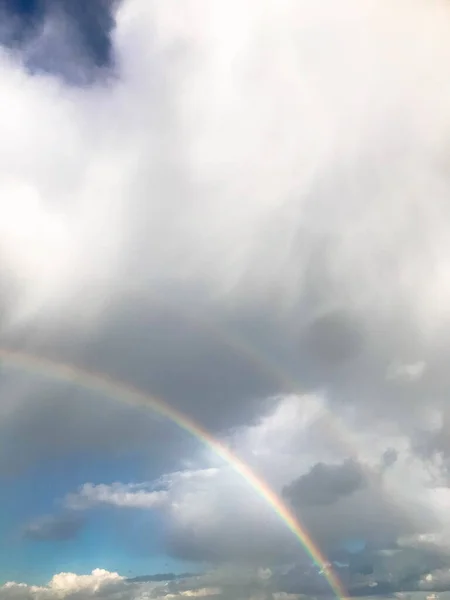Strahlender Regenbogen am grauen Regenhimmel. doppelter Regenbogen, die Manifestation von Regentropfen in verschiedenen Farben zwischen den Wolken. ein einzigartiges Naturphänomen, Romantik, Schönheit am Himmel — Stockfoto