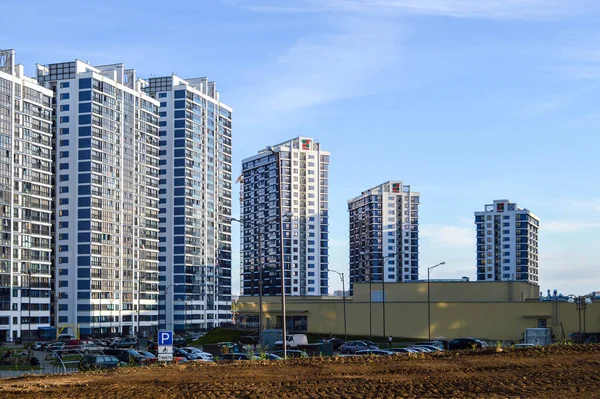 Blaue große Glashäuser in der Innenstadt. Hohe Wohngebäude für Menschen, moderne Gebäude. Im Zentrum befindet sich ein einzigartiges beigefarbenes Einkaufszentrum. Stadtlandschaft — Stockfoto