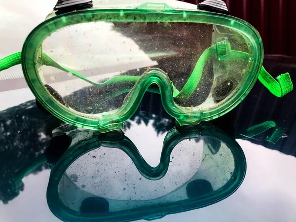 Γυαλιά για το κούρεμα του γκαζόν. προστασία των οφθαλμών από βλάβη του χόρτου και του κερατοειδούς. πλαστικά γυαλιά, πράσινο πλαίσιο με ελαστικές ταινίες στα αυτιά. στολή κηπουρού — Φωτογραφία Αρχείου