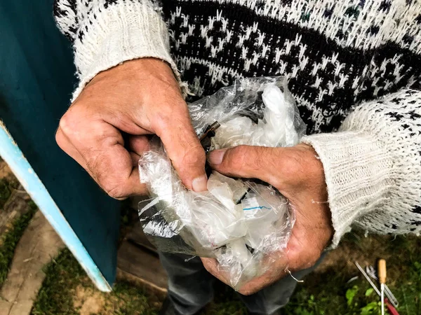 Adamın elinde içinde onarım aletleri olan bir paket var. Altın yüzüklü bir adam çivileri, somunları, cıvataları ayırıyor. DIY ev tamiri. ev atölyesi — Stok fotoğraf