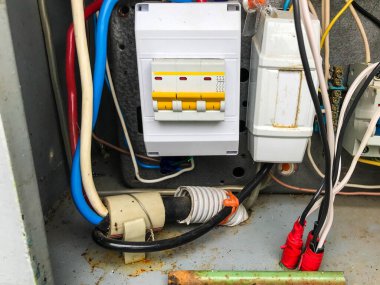 Ev yapımı elektrik paneli. Gri metre ve enerji tüketim göstergesi. Akım iletmek için kalın kablolar. Güç transferi için kalın kablolar örüyor