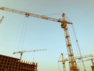 İnşaat vinci, ağır yükler için metal bir inşaat alanında duruyor. Ağır malzemeler taşıyordu. Ev inşaatı ve yeni bir alan. beton bloklar, gri binalar