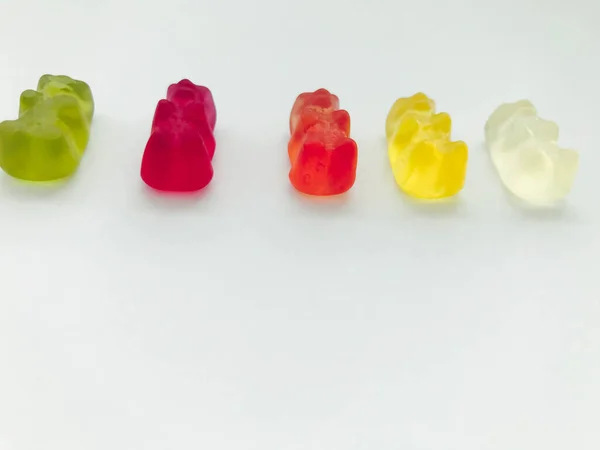 Gummy αρκούδες φωτεινό, διαφορετικά χρώματα σε ένα μπλε ματ φόντο. πεντανόστιμες καραμέλες με ασυνήθιστο σχήμα. επιδόρπιο με πολλές θερμίδες. θερμίδες για αύξηση βάρους, γλυκύτητα ζάχαρης — Φωτογραφία Αρχείου