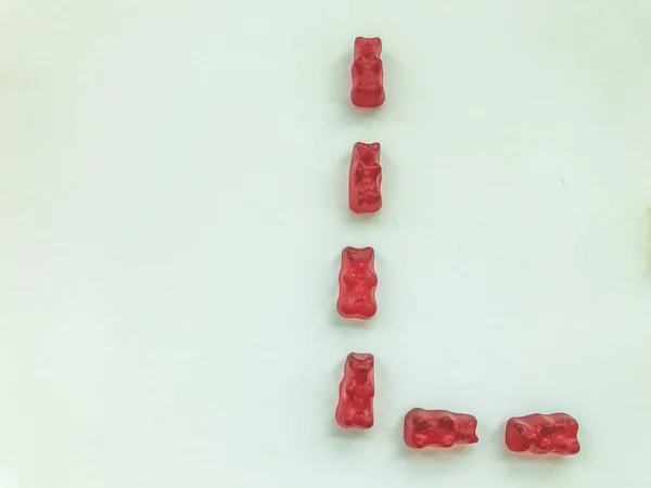 Δημιουργικό βρώσιμο γράμμα L φτιαγμένο από ζελεδάκια. Γράμμα από κόκκινα, ζελατινώδη και νόστιμα γλυκά. δημιουργική εικόνα των λέξεων. νόστιμο γράμμα υψηλής θερμίδων — Φωτογραφία Αρχείου