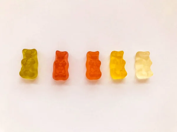 Gummy αρκούδες φωτεινό, διαφορετικά χρώματα σε ένα ροζ ματ φόντο. πεντανόστιμες καραμέλες με ασυνήθιστο σχήμα. υψηλής θερμιδικής αξίας, γλυκό επιδόρπιο — Φωτογραφία Αρχείου