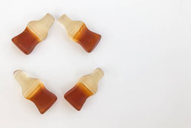 Bir jelatin topu, beyaz bir arka planda limonata ile şişe şeklinde yapılmış bir daire şeklinde dizilir. Noel ağacındaki oyuncak gibi sıralanmış şekerlemeler.