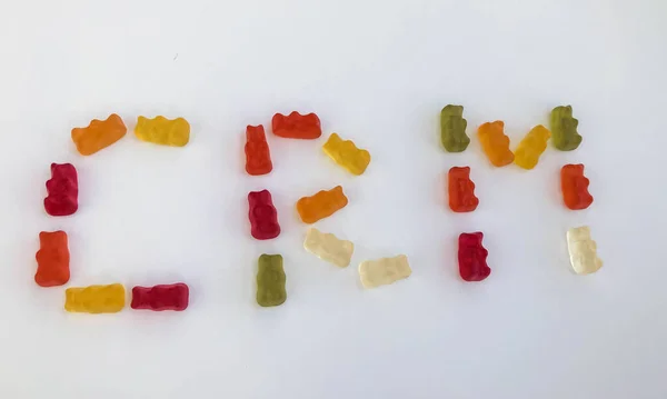 word from gummy gummy bears. edible letters C, R, M. vitamin and edible word. English alphabet. delicious appetizing dessert. bright bears on a white matte background