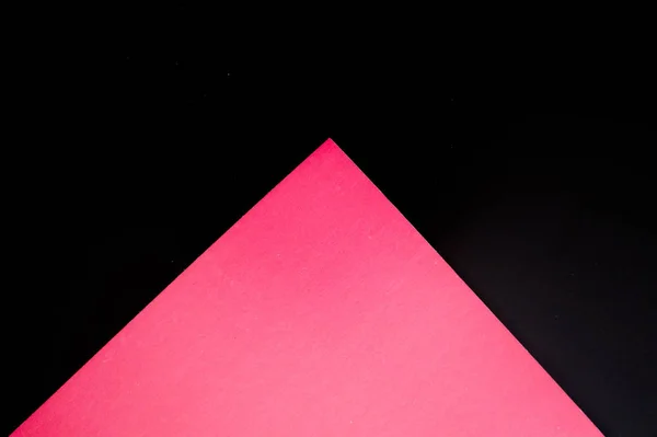 Dark flat lay background with color paper sheets. Black and pink.