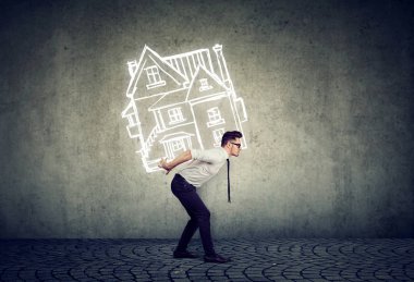 Overburdened business man carrying a house on his back  clipart