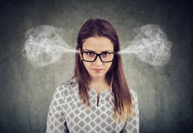Closeup portrait of angry woman, blowing steam coming out of ears isolated on gray background. Negative human emotions feelings clipart