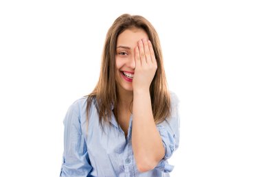 Oldukça mutlu genç esmer bir göz kapsayan ve beyaz arka plan üzerinde kamera duran gülüyorsun mavi gömlekli