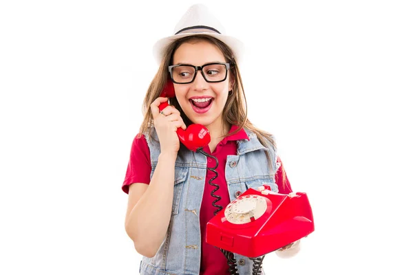 时髦的年轻女子在帽子和眼镜看着惊讶 而在复古手机上的白色背景隔离 — 图库照片