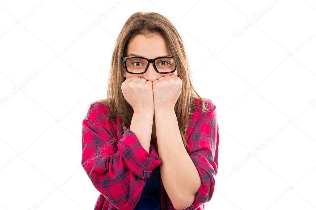 Young woman in glasses and plaid shirt covering mouth in fear and panic looking at camera isolated on white background