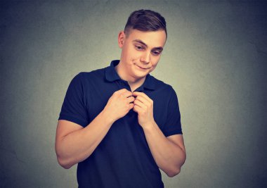 Utangaç ve sessiz gri arka plan holding üzerinde görünen genç casual adam tereddüt eller