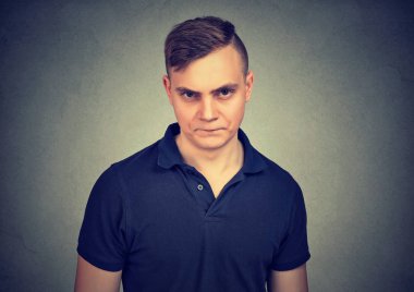 Genç nefret dolu çatık ve tiksinme gri arka plan üzerinde kamera bakıyorsun adam