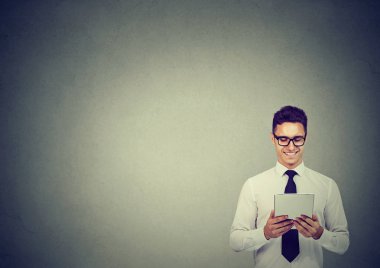 Gözlük tablet gri arka plan üzerinde izlerken neşeli zarif adam