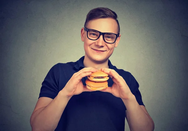 Giovane Uomo Sorridente Occhiali Possesso Pochi Hamburger Sorridente Alla Fotocamera — Foto Stock