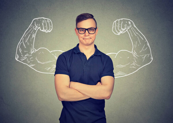 Smart man holding arms crossed with muscular hands behind back looking at camera on gray background