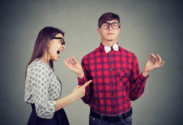 Young woman in anger yelling at boyfriend in glasses trying to keep calm in meditation — Stock Image Young Woman Anger Yelling Boyfriend Glasses Trying Keep Calm Meditation Stock Photo