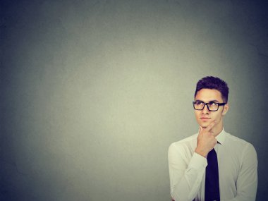 Gömlek ve gri arka plan üzerinde çene dokunmadan mindfulness ararken gözlük resmi adam