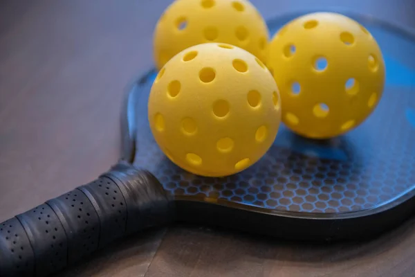 Küreğin üzerinde pişti topları. Pickleball sporu Amerika 'nın en hızlı büyüyen sporlarından biridir..