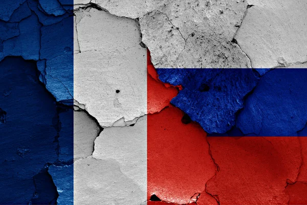 法国和俄罗斯的国旗挂在裂开的墙上 — 图库照片