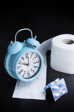 Tuvalet kağıdı, kapsül ve çalar saat siyah