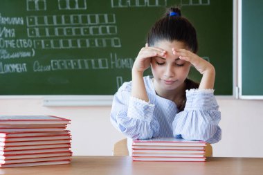 Blackboard sınıfta karşı kız oturur kitap bir bakar vurguladı