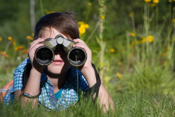 Pojke ung forskare utforskar med kikare miljö i sommarträdgård — Stockfoto