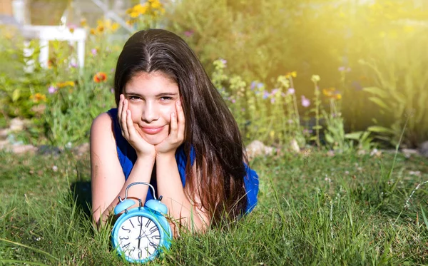 Girl with blue alarm clock in summer — Stock Photo, Image